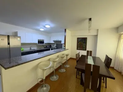 a kitchen with a table and chairs and a counter at Duplex en miraflores av larco 1010 in Lima