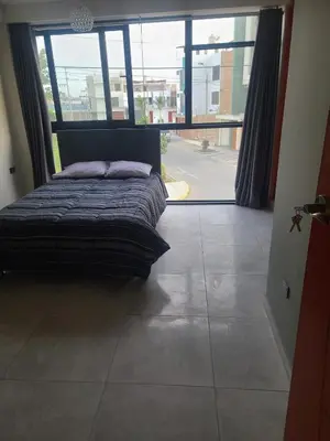 a bed in a room with a large window at Departamento en ica de estreno in Ica