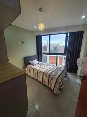 a bedroom with a bed and a large window at Departamento en ica de estreno in Ica
