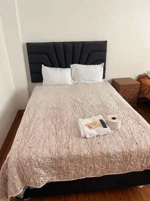 a bed with a black headboard and a book on it at hospedaje Illary in Quinua
