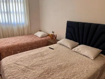 a bedroom with two beds and a black headboard at hospedaje Illary in Quinua