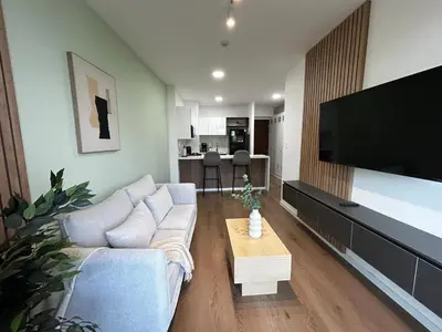 a living room with a couch and a flat screen tv at Loft Bohemio a 1 cuadra de plaza Barranco in Lima
