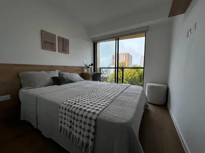 a bedroom with a large bed and a large window at Loft Bohemio a 1 cuadra de plaza Barranco in Lima