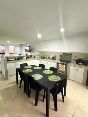 a kitchen with a black table and chairs in a room at Exclusivo departamento cerca al mar in Quebrada Seca