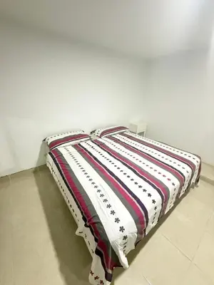 a bed with a striped blanket on top of it at Exclusivo departamento cerca al mar in Quebrada Seca