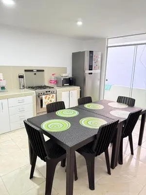 a kitchen with a table and chairs in a room at Exclusivo departamento cerca al mar in Quebrada Seca