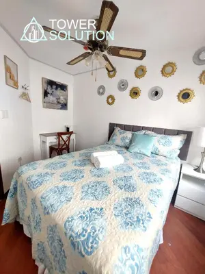 a bedroom with a bed with a blue and white comforter at Casa Cayena in Lima