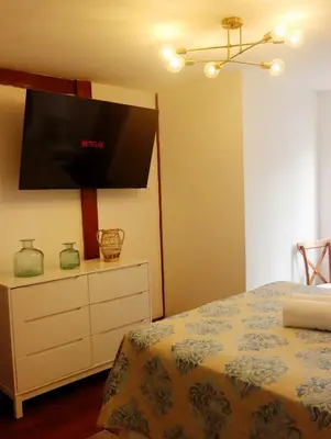 a bedroom with a bed and a tv on the wall at Casa Cayena in Lima