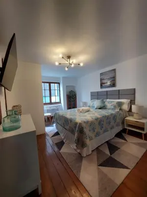 a bedroom with a bed and a table and a window at Casa Cayena in Lima