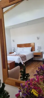 a bedroom with a bed and a large mirror at Florez de la Villa Apart Hotel in Cusco