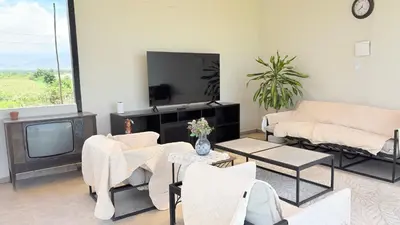 a living room with a couch and a tv at Casa San José - Bungalow 5 in Ica