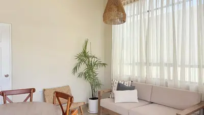 a living room with a couch and a window at Casa San José - Bungalow 5 in Ica