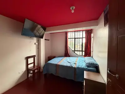 a small bedroom with a bed and a window at Hospedaje Tarapacá in Huancayo