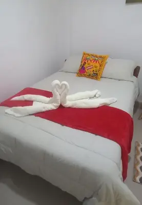 a white bed with a red and white blanket at Inti Wasi Z in Cusco