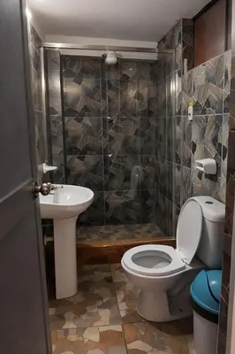 a bathroom with a toilet and a sink at Hospedaje Tikari in Chinchero