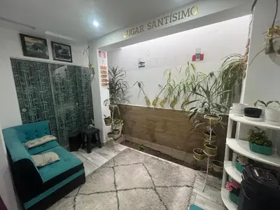 a room with a blue chair and plants on the wall at Ministery The Bleasing in Lima