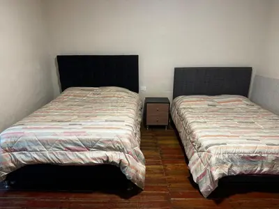 two beds sitting next to each other in a bedroom at Posada Bayoneta in Cusco