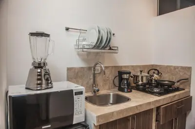 a kitchen with a sink and a blender on a counter at Florez de la Villa Apartments in Urubamba