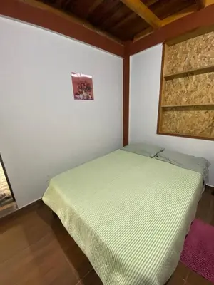 a small bedroom with a bed in a room at Cabañas Vivenciales La Colina in Oxapampa