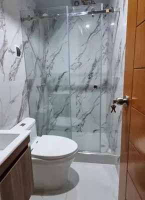 a bathroom with a toilet and a glass shower at Cusco Apartment Prime Location in Cusco