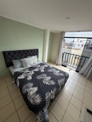 a bedroom with a bed with a black and white blanket at Casa de playa in Arica