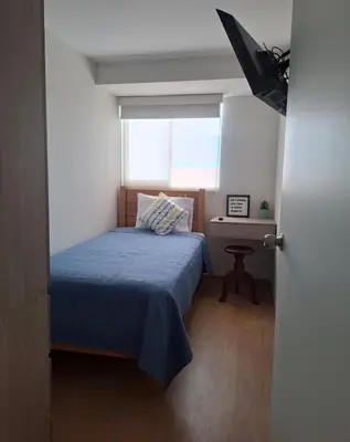 a small bedroom with a bed and a window at Cómoda habitación con TV a 20 min del aeropuerto in Lima