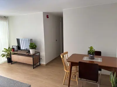 a living room with a dining room table and a television at Amplia habitación con baño propio a 20 min del aeropuerto in Lima