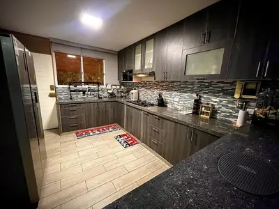 a kitchen with wooden cabinets and a counter top at Casa de Campo Quives Majestuoso 5BR in Santa Rosa de Quives
