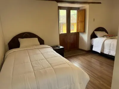 a bedroom with a bed and a window at plaza inn in Ollantaytambo