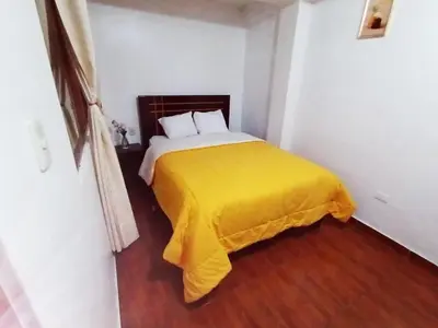 a bedroom with a bed with a yellow blanket at Destinos Peru Inn - Destinos in Machu Picchu