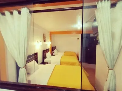 a bedroom with two beds and a large mirror at Destinos Peru Inn - Destinos in Machu Picchu