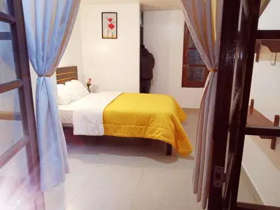 a bedroom with a bed with a yellow blanket at Destinos Peru Inn - Destinos in Machu Picchu