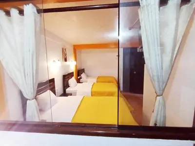 a mirror in a bedroom with two beds in it at Destinos Peru Inn - Destinos in Machu Picchu