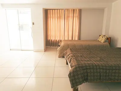 a hotel room with two beds and a window at Departamento en Ayacucho in Ayacucho
