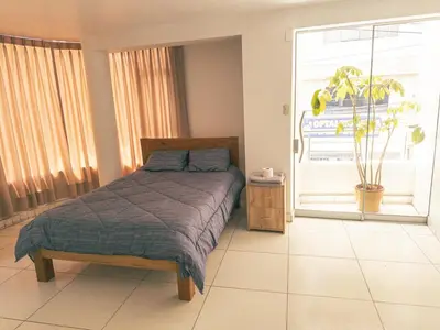 a bedroom with a bed and a large window at Departamento en Ayacucho in Ayacucho