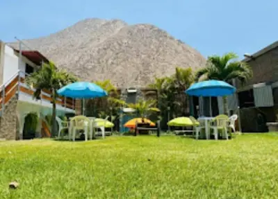 a group of tables and chairs with umbrellas in a yard at Inka Palace Resort in Santa Eulalia