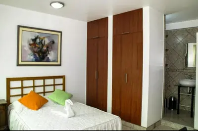 a bedroom with a bed with orange and green pillows at Inka Palace Resort in Santa Eulalia