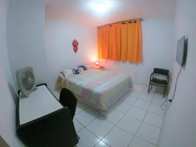 a bedroom with a bed and a table and a chair at Waves Surf Camp Peru in Punta Hermosa
