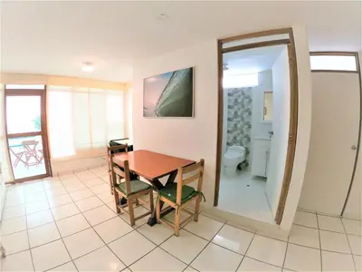 a dining room with a table and a bathroom at Waves Surf Camp Peru in Punta Hermosa