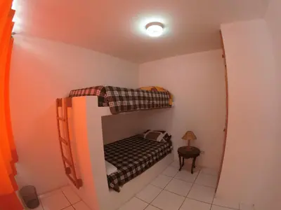 a small room with a bunk bed in it at Waves Surf Camp Peru in Punta Hermosa
