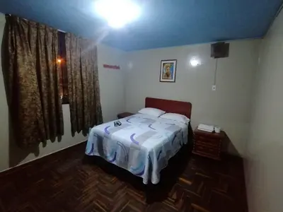 a small bedroom with a bed and a window at Kenko in Lima