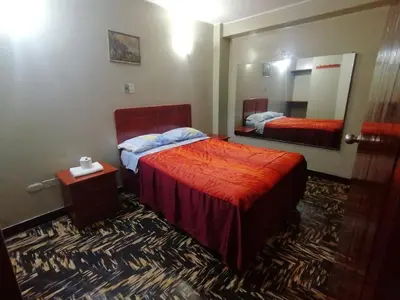 a hotel room with a bed and a mirror at Kenko in Lima