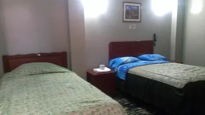 a room with two beds in a hotel room at Kenko in Lima