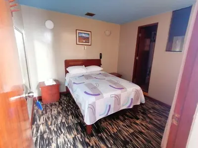a bedroom with a bed with a white comforter at Kenko in Lima