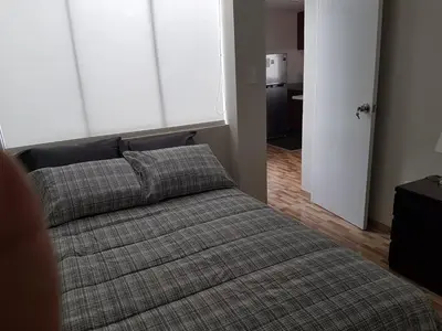 a bedroom with a bed and a window and a door at Lima Flats in Lima