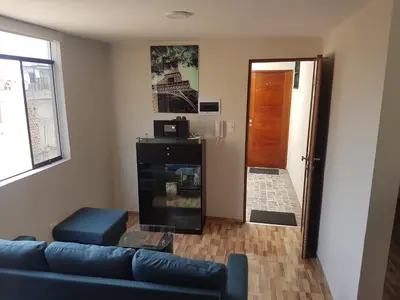 a living room with a blue couch and a door at Lima Flats in Lima