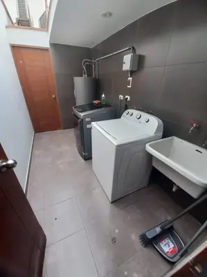 a small kitchen with a washing machine and a sink at Larcomar Luxury Penthouse in Lima