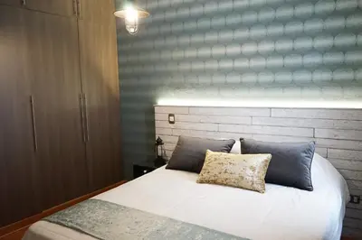 a bedroom with a white bed with two pillows at Larcomar Luxury Penthouse in Lima