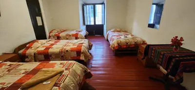 a room with three beds in a room at Hostel Imperial BACKPACKER in Cusco