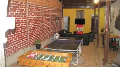 a ping pong table in a room with a brick wall at Hostel Imperial BACKPACKER in Cusco